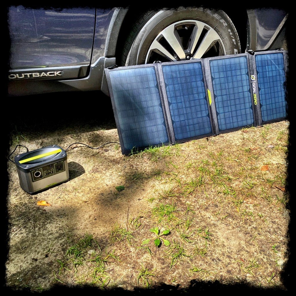 Solar panels leaned against our car in the sun to charge the Yeti