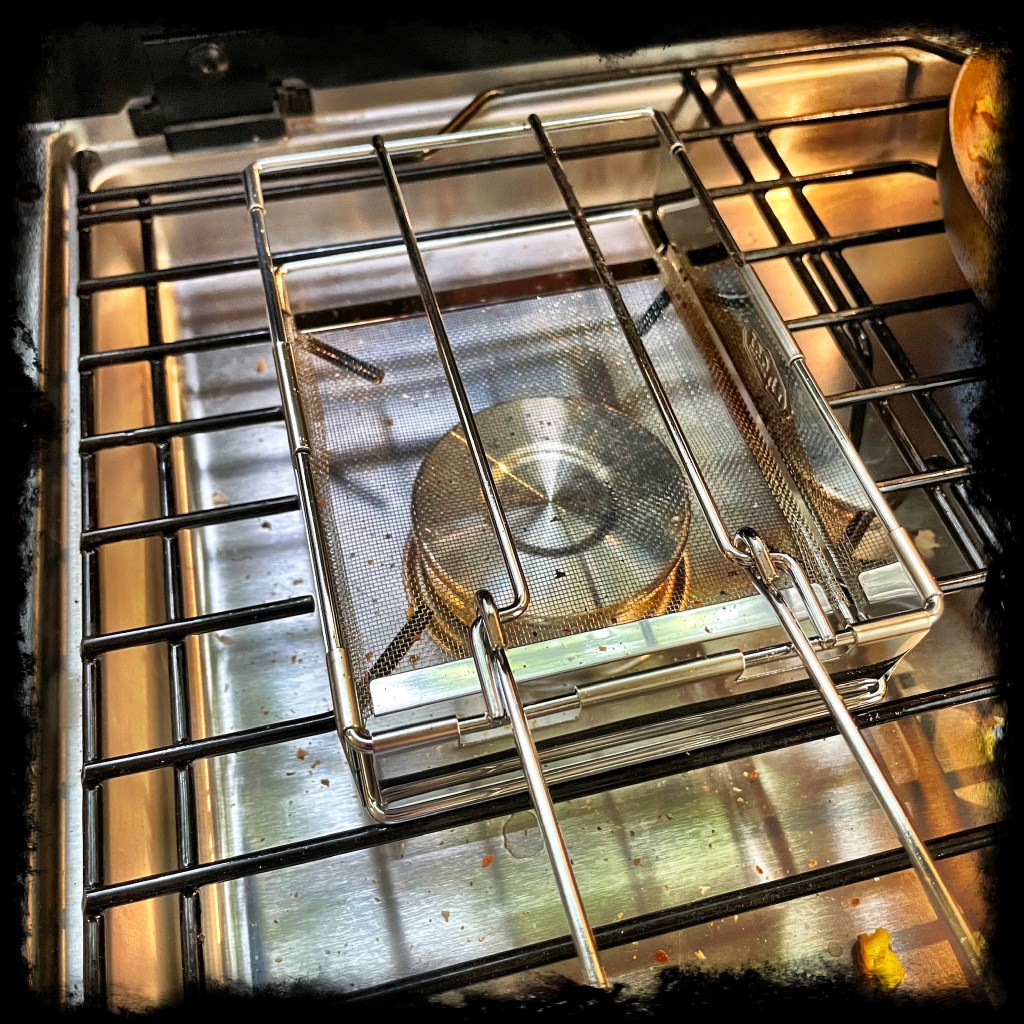 GSI toaster device folded and on burner ready to toast