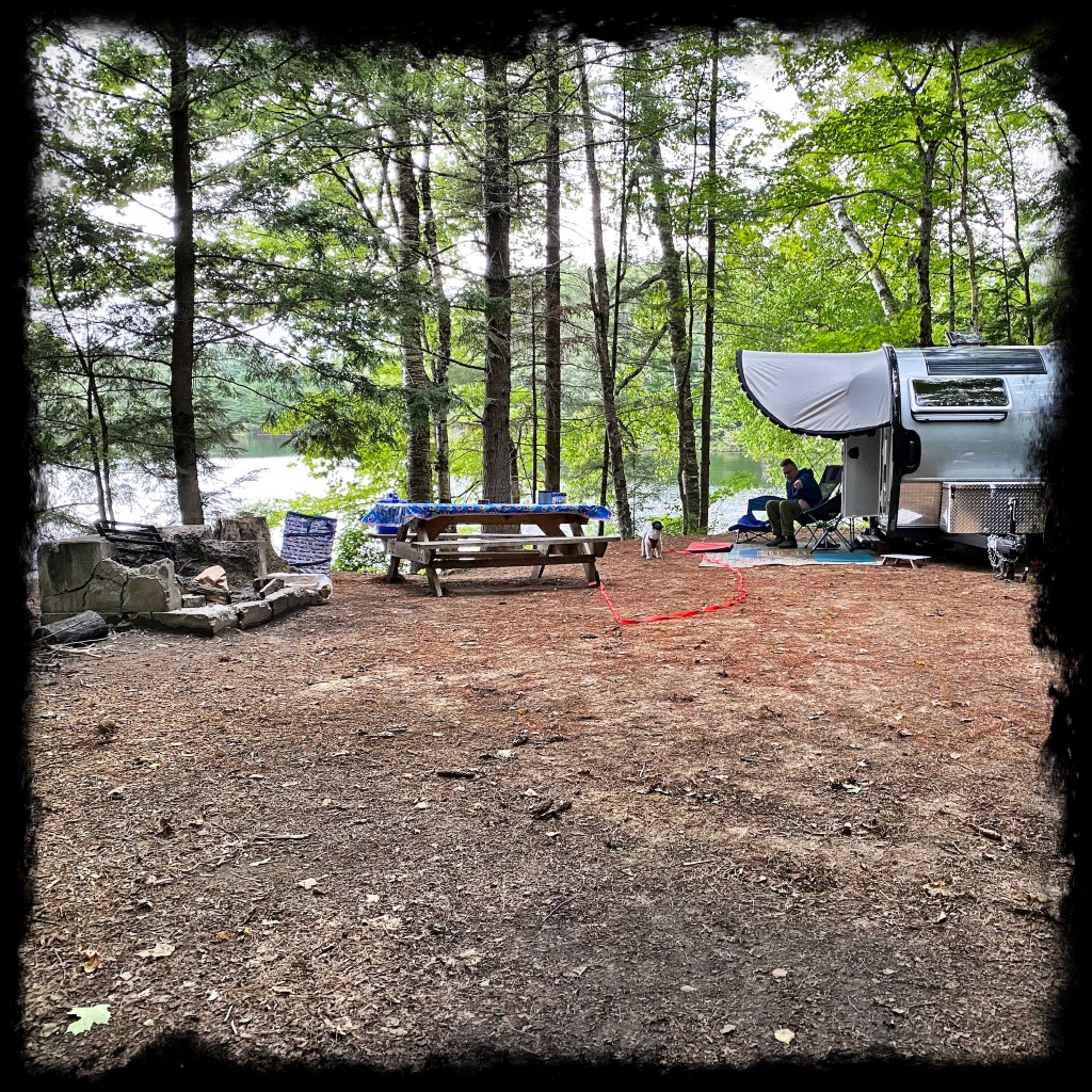 View of Camper at campsite along the edge of the pond