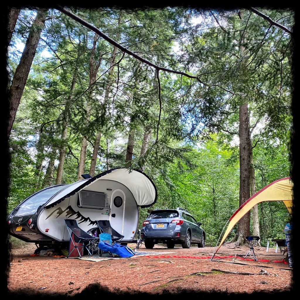 View of camper, car and shelter on a misty morning