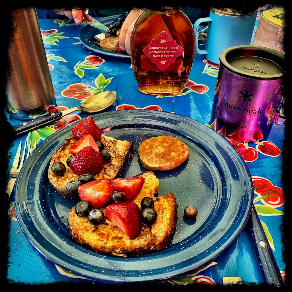 Plate with french toast, strawberries and blueberries with sausage and syrup